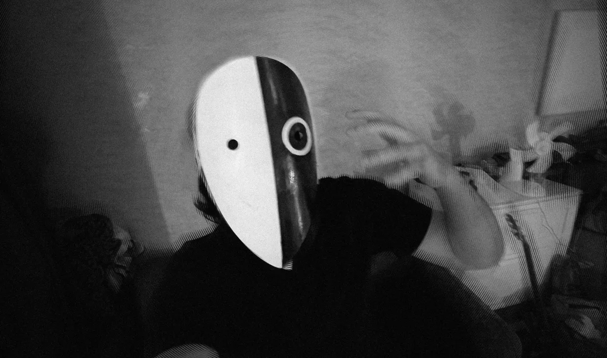 IMP Dariush in the mask, raising a hand